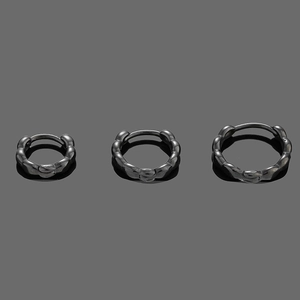 Macro view of black twisted hoop earrings in three sizes with textured wave design