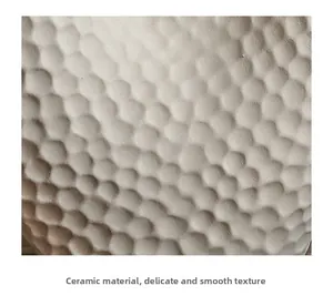 Détail macro d'un vase en céramique blanc cassé avec motifs géométriques alvéolés