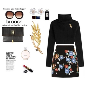 Detail of a golden wheat stalk brooch with rhinestones on a black turtleneck sweater
