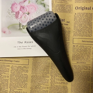 Detail of ice roller massage tool with gray textured head on vintage newspaper background