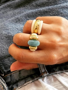 Detail of vintage gold ring with amazonite turquoise stone on denim background