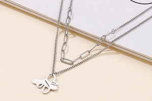 Detail of silver double-layered necklace featuring paperclip chain and abstract pendant