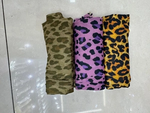 Close-up of leopard print pantyhose fabric in olive, purple and classic yellow colors