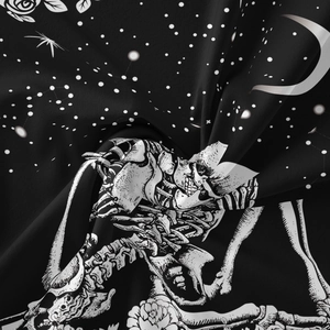 Detailed macro shot of gothic tapestry fabric showing skull, roses, and moon patterns