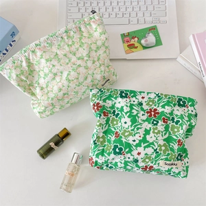 Close-up of green floral pattern cotton fabric cosmetic bags with Sozakka brand tag