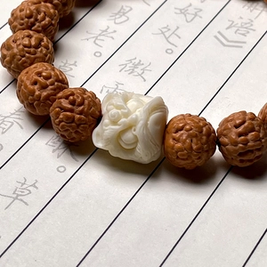 Detailed view of Rudraksha bead bracelet with a white carved guardian lion charm