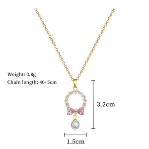 Detail view of gold necklace with pink bow zircon heart and pearl, 40+5cm length