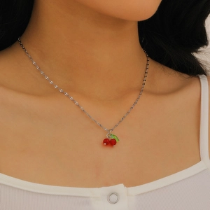 Close-up of sweet cherry pendant necklace with red beads on silver chain for women