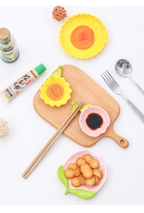 Detailed close-up of ceramic tulip and peach shaped snack plates on a wooden board