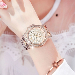 Detail of rose gold luxury watch with crystal bezel and chronograph dial on wrist