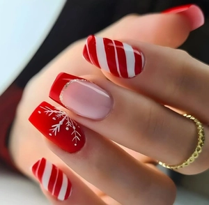 Macro view of long square red and white Christmas nails with snowflakes and golden glitter