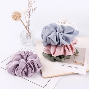 Close-up of velvet checkerboard hair scrunchies in pastel purple, blue, pink and dark green