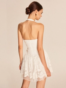 Back view of white lace halter mini dress with open back and embroidery details