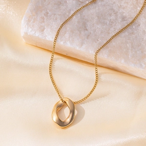 Close-up of 18K gold plated necklace with irregular round pendant on white stone