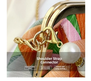 Close-up of golden hardware, pearl charm, and colorful textured leather bag details