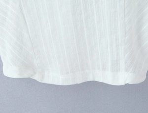 Detailed macro view showing vertical fabric texture and stitching on white polo top