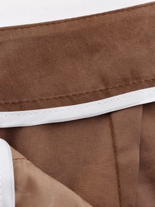 Close-up of contrast piping and stitching detail on dark brown blazer shorts