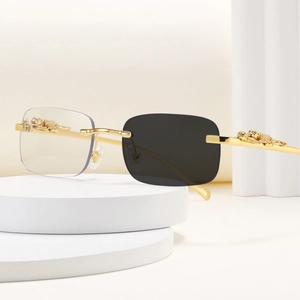 Detalle de gafas de sol cat-eye sin montura con relieve de guepardo dorado en patillas