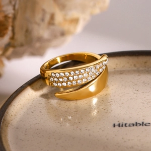 Macro detail of gold-plated wrap ring featuring leaf shape and triple-row zircon inlay