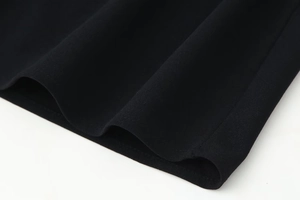 Macro detail of the black sleeveless maxi dress showing smooth fabric texture and hemline