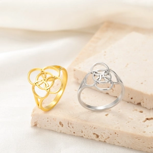 Intertwined Celtic knot rings in gold and silver stainless steel on stone