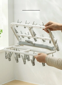 Foldable laundry drying rack with multi-clips for socks shown in a space-saving design