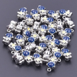 Close-up of bulk astronaut pendants with blue glitter helmets and yellow stars