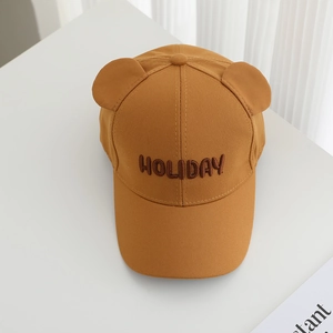 Detail of mustard yellow baby baseball cap with holiday embroidery and cute bear ears