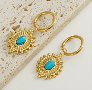 Détail de boucles d'oreilles vintage bohème en turquoise et acier inoxydable doré