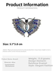 Detailed view of silver butterfly brooch with blue rhinestones measuring 5.1x3.8 cm