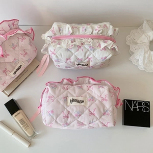 Close-up of quilted cotton makeup bags with floral ribbon patterns and pink ruffle trim