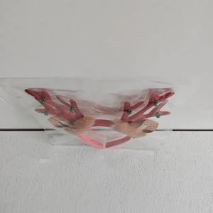Close-up of a festive red glitter reindeer antler headband in transparent packaging