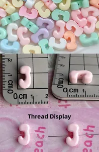 Macro detail of colorful C-shaped resin beads showing exact dimensions and stringing