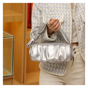 Detail shot of the silver ruched cloud bag with a knotted strap and metallic PU leather