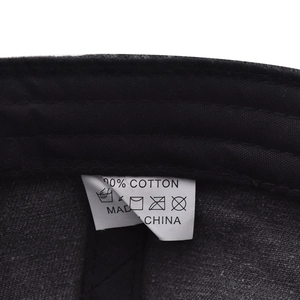 Detail view of the 100% cotton inner sweatband and care label of the black baseball cap