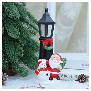 Close-up of lit vintage street lamp ornament with Santa and snowman Christmas decor