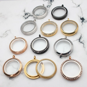 Detail of round glass locket pendants in silver gold rose gold and black metal finishes
