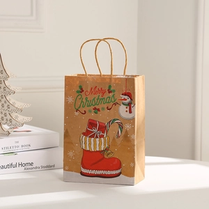 Brown kraft paper Christmas gift bag with snowman and stocking print in a cozy setting