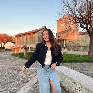Giacca da baseball blu navy con crop top bianco e gonna midi in denim con spacco
