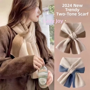Detail of the knit winter scarf featuring a two-tone color block and cross-buckle design