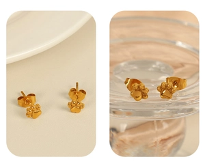 Détail macro de boucles d'oreilles pattes de chat dorées en acier titane 18K