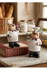 Rustic chef figurines with cake and fruit on marble tabletop kitchen decor