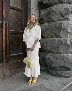 Detail of white V-neck tie-front crop top with puffy sleeves and cotton skirt set