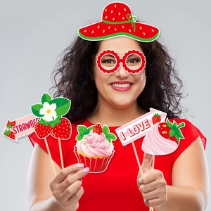 Strawberry birthday party photo booth props kit with strawberry hats and themed paper signs