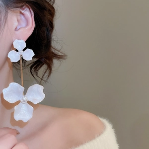 Detail of white flower earrings with pearls on a model in vintage French style