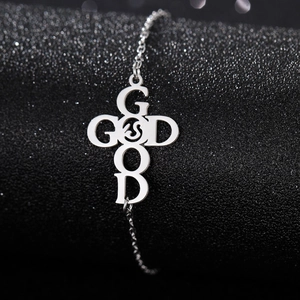 Macro detail of silver stainless steel cross bracelet featuring GOD and GOOD engraving