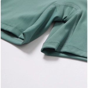 Macro detail of high-elasticity turquoise yoga shorts showing reinforced flatlock stitching