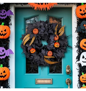 Detail of Halloween wreath with black maple leaves, orange pumpkins and gold accents