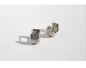 Detailed close-up showing the molten lava texture on these silver metal square earrings
