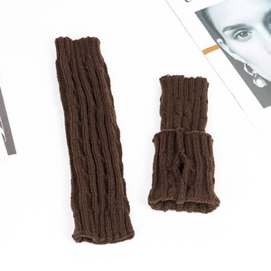 Detail of brown cable knit arm warmers with thumb hole and soft acrylic texture